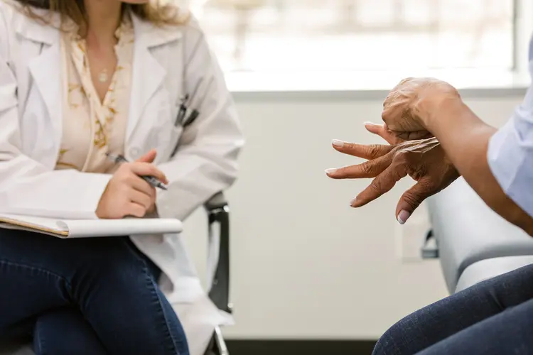 photo of woman showing hand to doctor