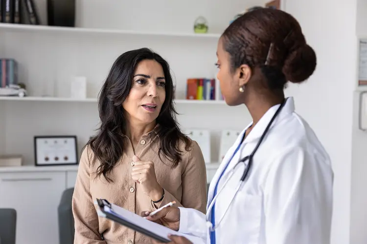 photo of woman talking to doctor