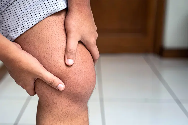 photo of man holds his swollen knee