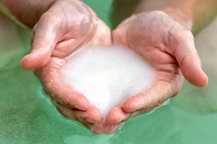 photo of Dead Sea salt in male hands, bath, Dead Sea Salt.