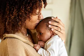 photo of mother kissing her baby boy