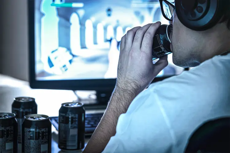 photo of Guy drinking energy drinks and playing video game