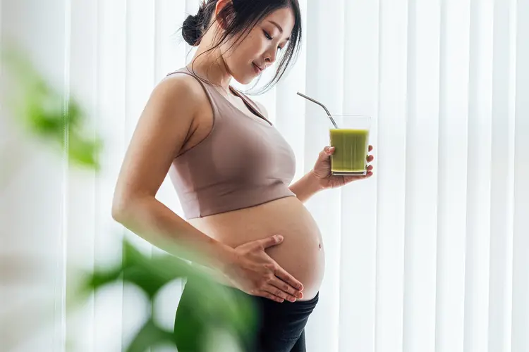 photo of pregnant woman having healthy juice 