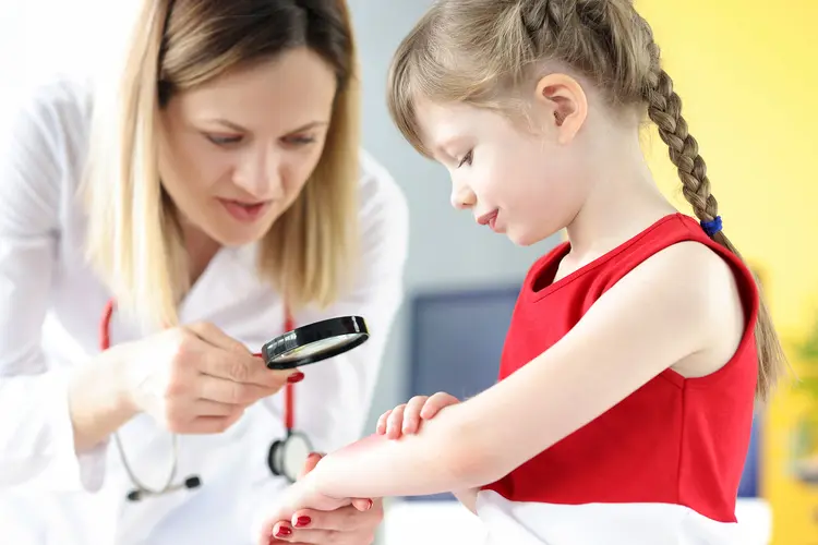 photo of pediatrician examining girl's forearm