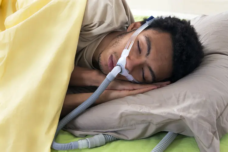 photo of young man using a CPAP machine while sleeping