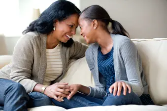 photo of mother and daughter bonding on sofa