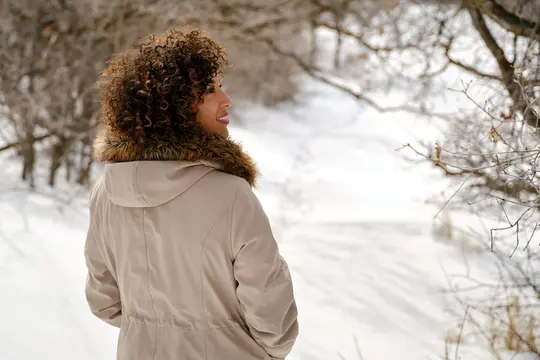 photo of young woman hiking in winter