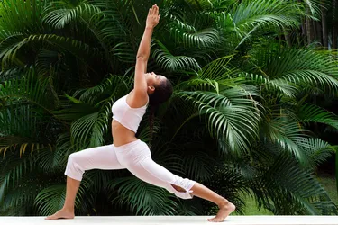 Warrior I pose, called Virabhadrasana I in Sanskrit, is a classical vinyasa pose that strengthens the lower body and core muscles, and builds balance and focus. (Photo credit: Moment/Getty Images)