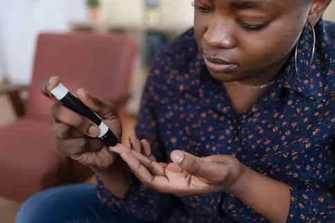 photo of woman using glucometer
