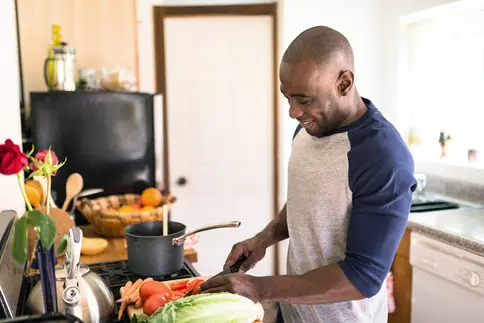 photo of happy man in kitchen preparing food