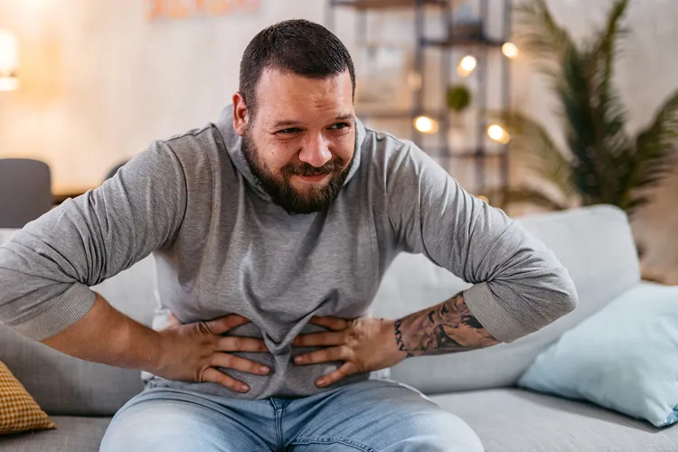 photo of man holding stomach