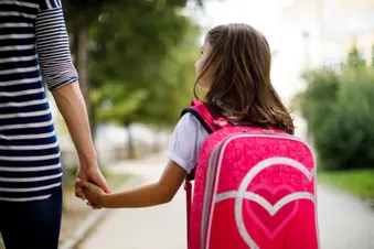 photo of mother taking her daughter to school