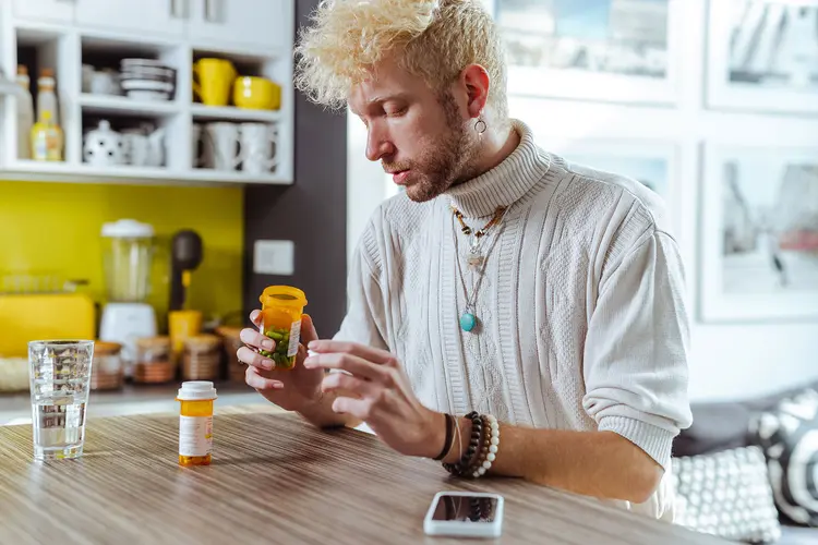 photo of man reviewing prescription pill bottles