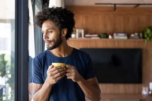 photo of young man drinking cup of coffee
