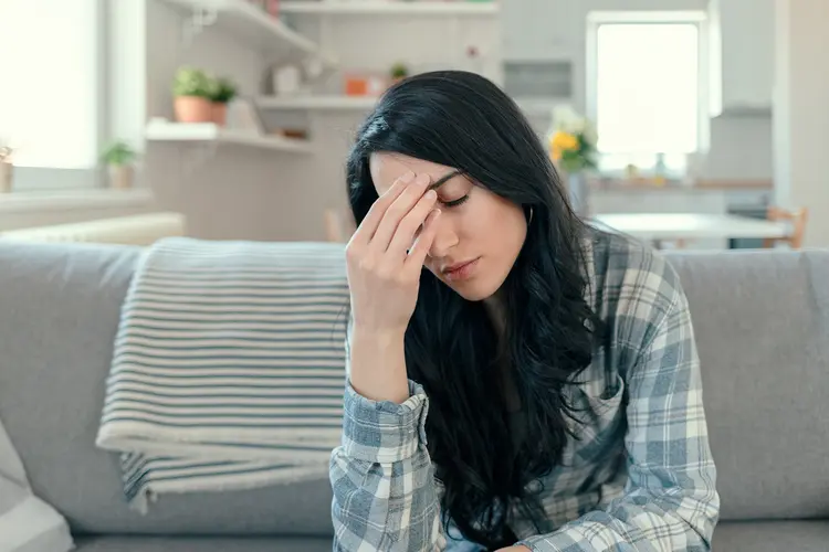 photo of woman with headache on couch