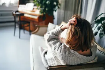 photo of woman with headache on sofa