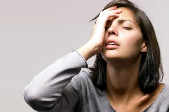 photo of anxious, young woman holding face