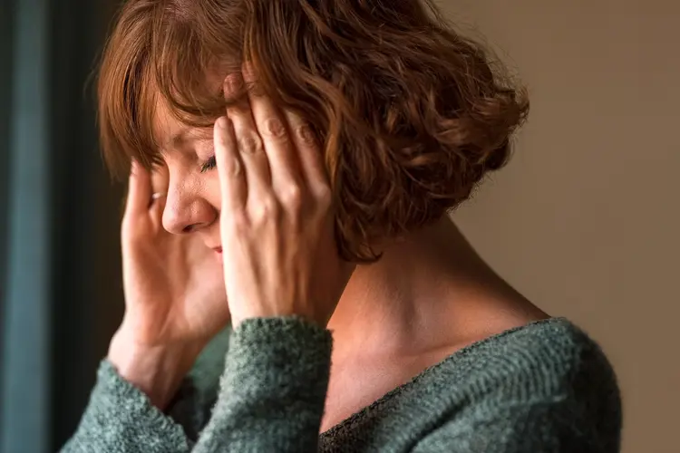 photo of woman with headache rubbing her temples