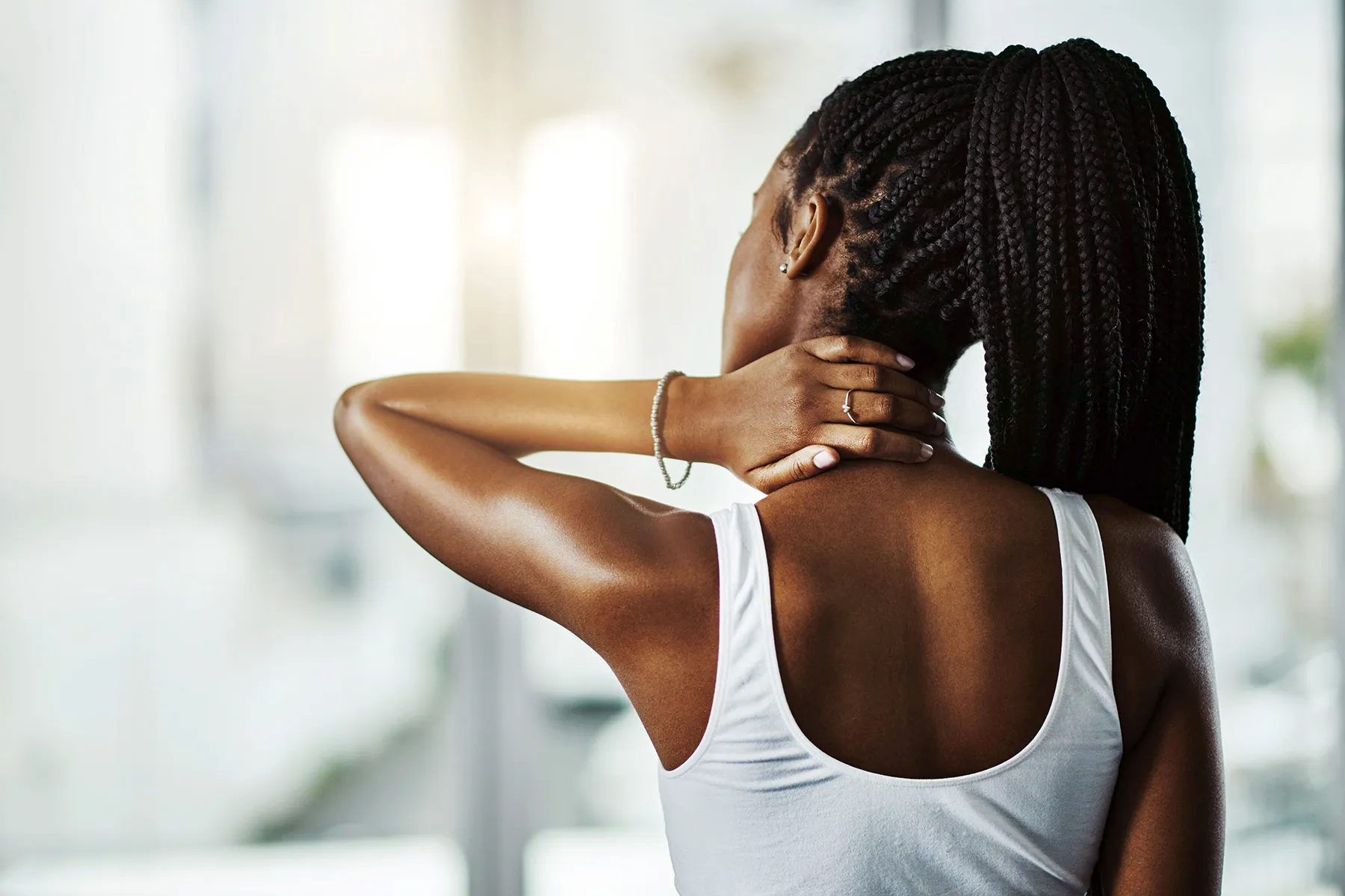 photo of woman massaging sore neck