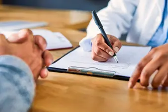 photo of doctor taking notes during patient exam