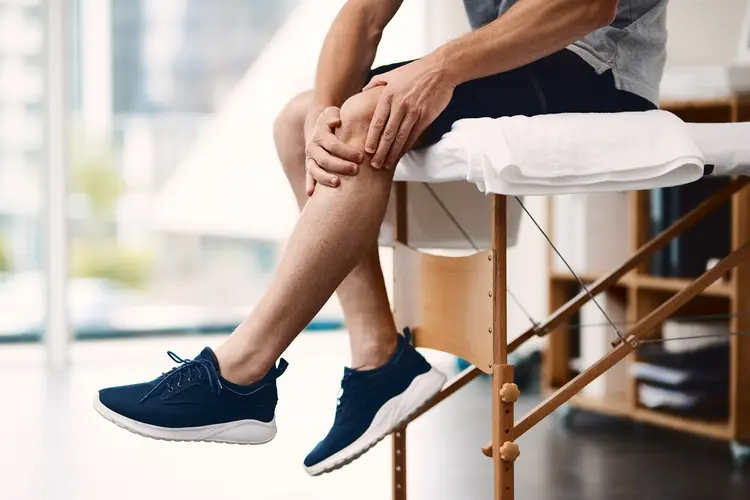 photo of man on examination table holding knee