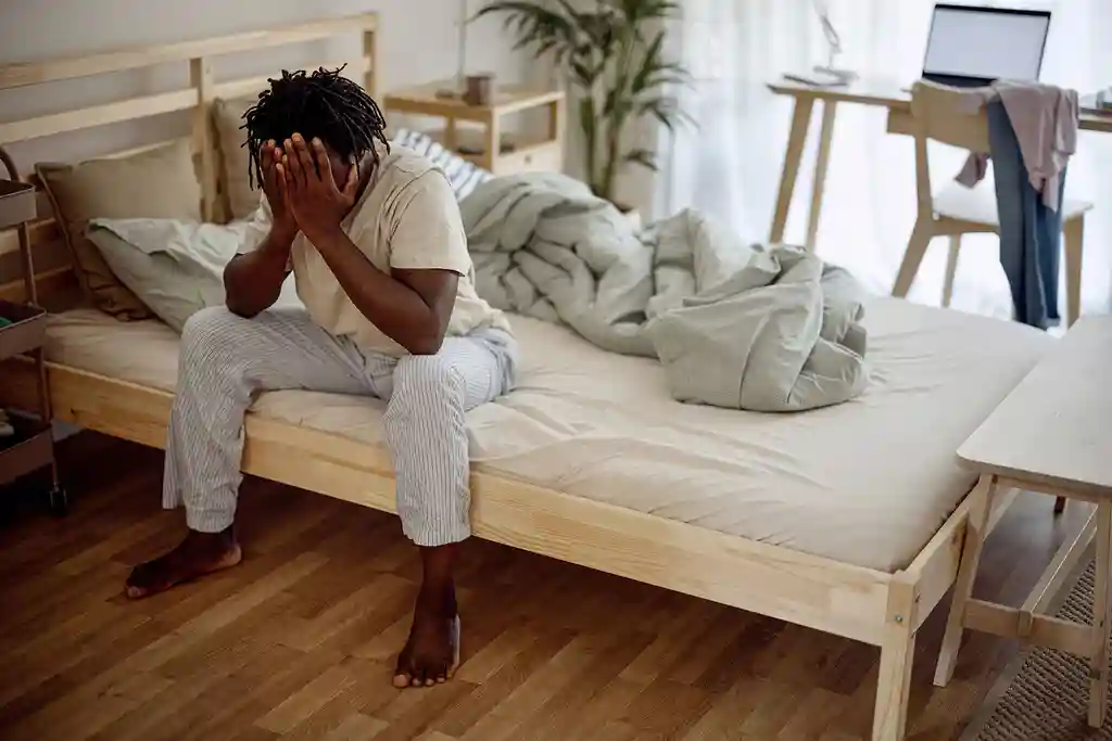 photo of man getting out of bed