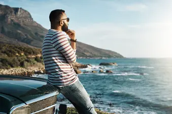photo of young man enjoying a road trip
