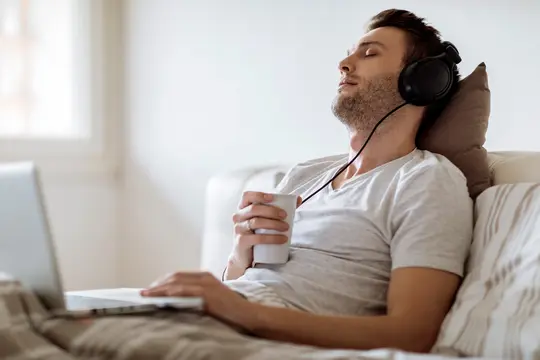 photo of young man listening to music