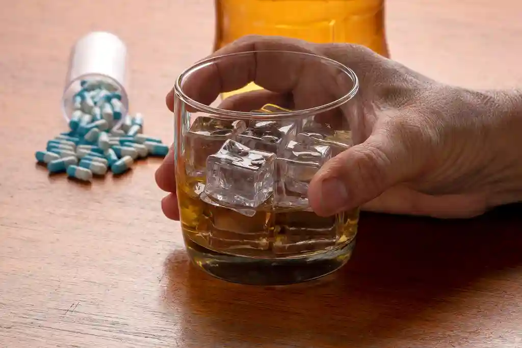 photo of man's hand holding whiskey glass