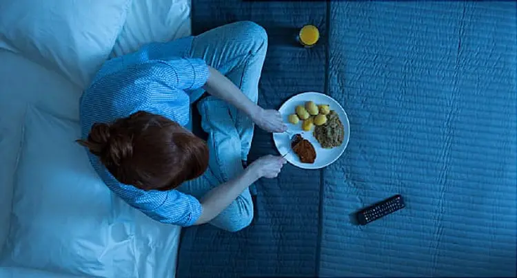 woman eating in bed