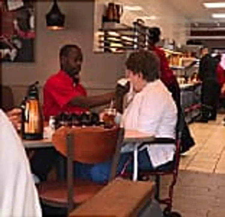 woman being fed by kind stranger