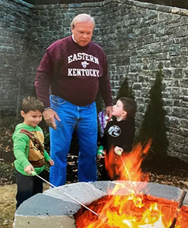 Ernest House makes smores with 2 of his 9 grandchildren.