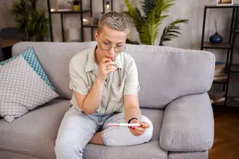 photo of woman watching pregnancy test