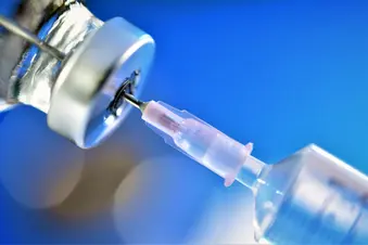 photo of syringe inject into drug bottle