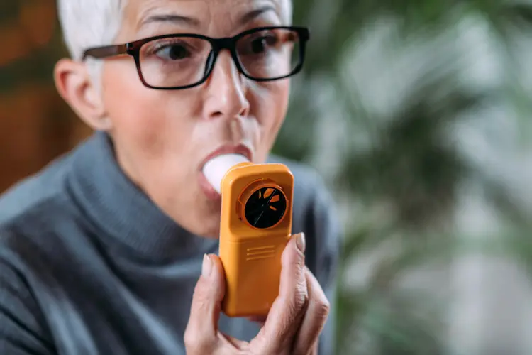 photo of woman using spirometer