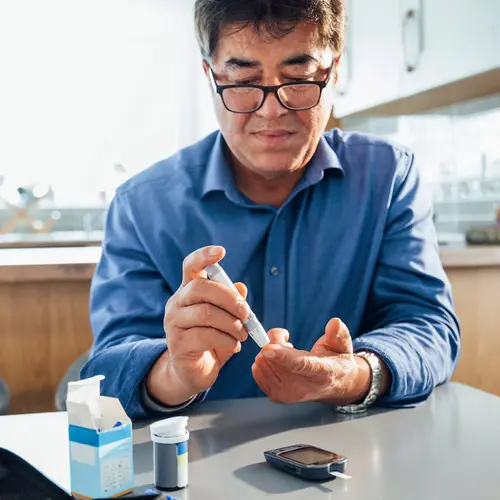 photo of man checking blood glucose