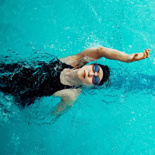 photo of woman swimming laps