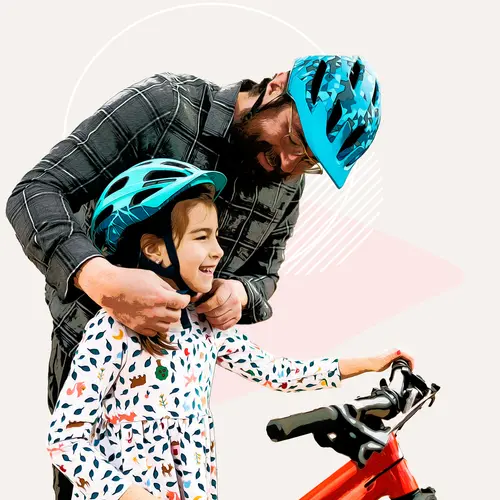 photo of dad with child wearing bike helmets