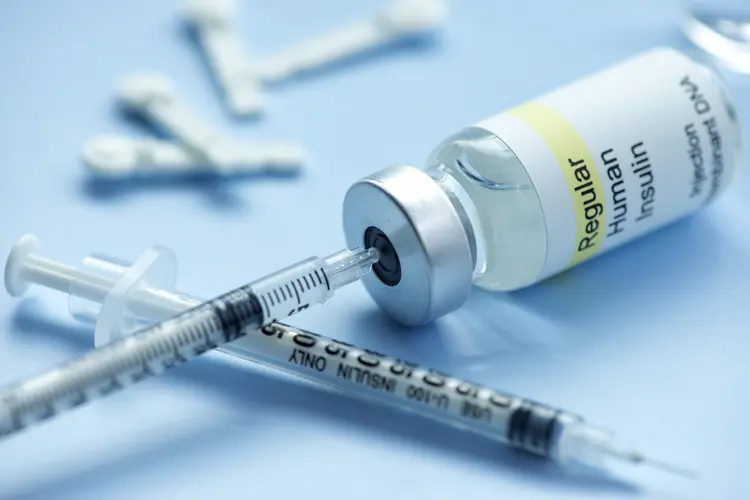 photo of Insulin vial with syringe and lancets.