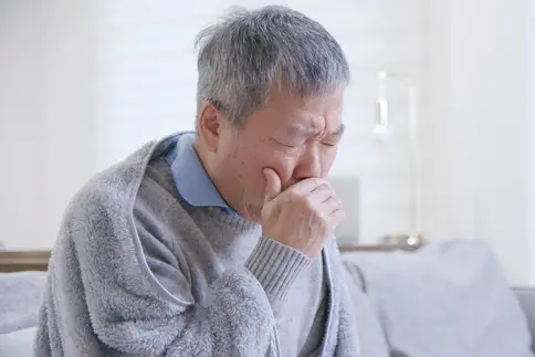 photo of coughing senior man
