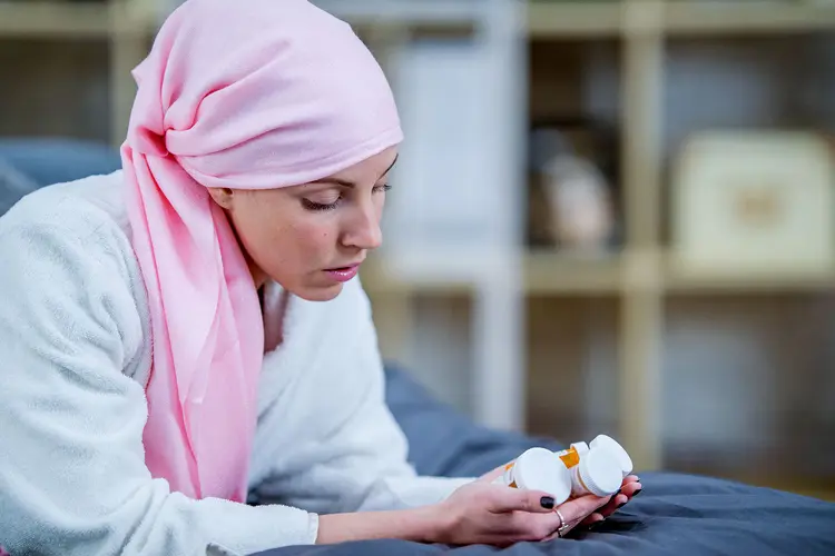 photo of cancer patient looking at medication bottles