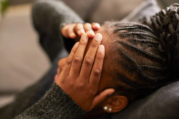photo of woman holding hands to head