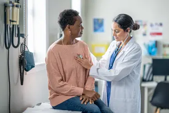 photo of doctor checking patient's heart with stethoscope