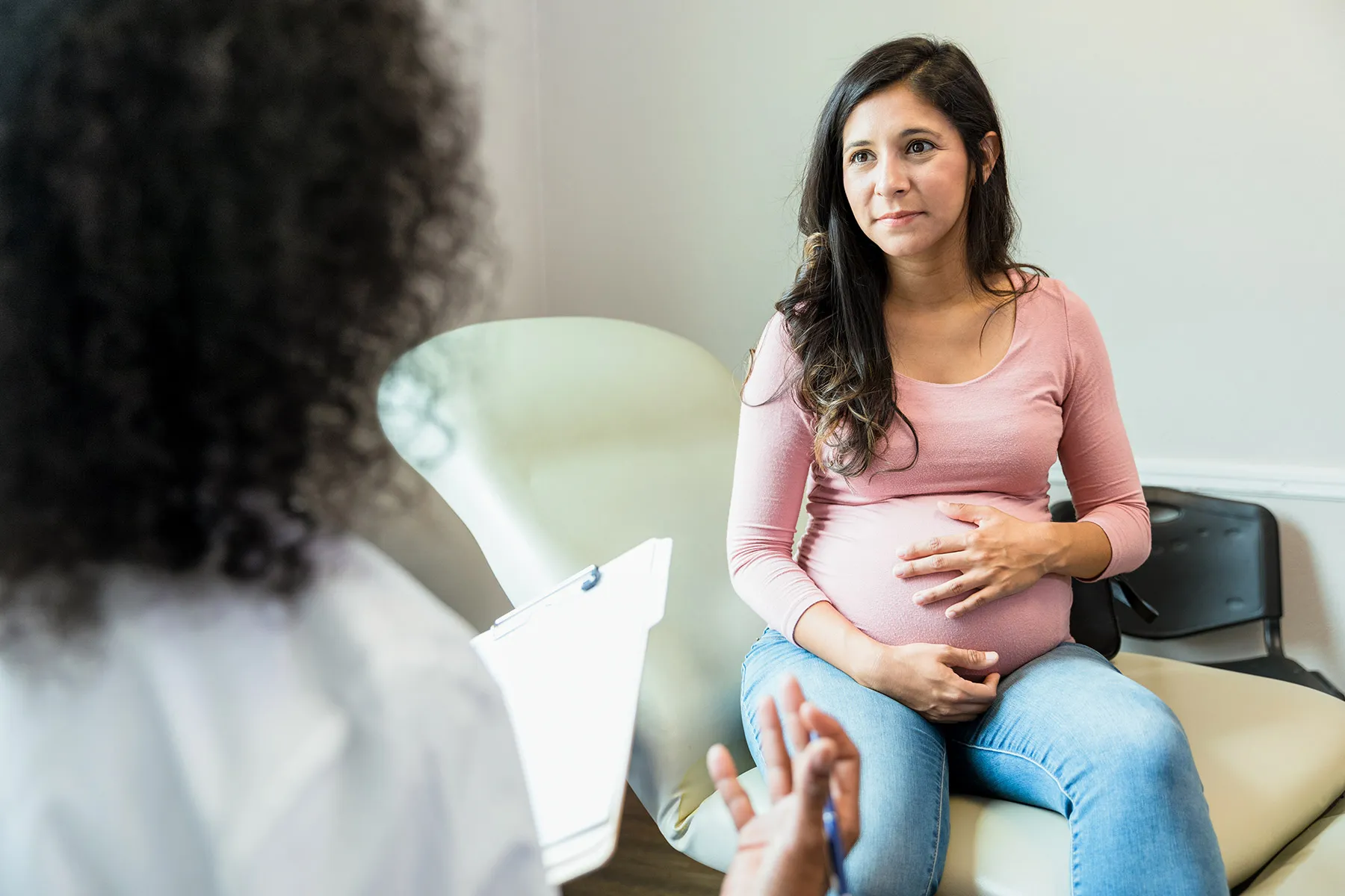 photo of pregnant woman talking with doctor