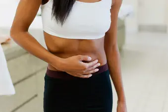 photo of woman holding stomach