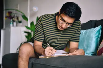 photo of man writing in journal