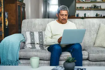 photo of senior man using laptop at home