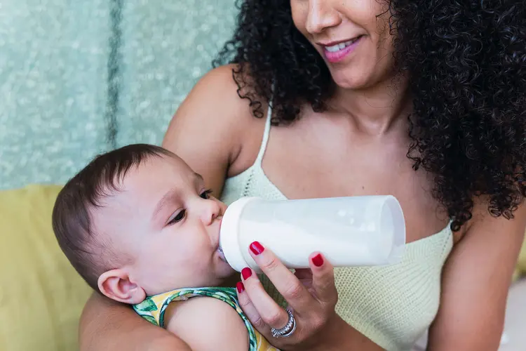 photo of mother feeding baby with bottle