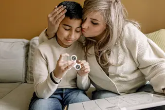 photo of mother kissing son
