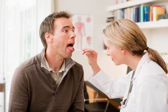 photo of doctor examining male patient's mouth